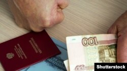 GENERIC – An elderly man is holding a pension certificate and money in his hands. Russia.