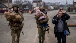 Ushtarët ukrainas ndihmojnë civilët për t'u larguar nga Kievi.