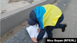 Un activist își pregătește pancarta pentru marșul solidarității cu femeile ucrainene și împotriva războiului, Chișinău, 8 martie 2022.