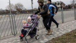 Soldat ucrainean ajutând la evacuarea civililor din Irpin, în apropiere de Kiev, 7 martie 2022.