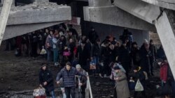 Ljudi prolaze ispod uništenog mosta dok pokušavaju da se evakuišu iz Irpina. Most je jedina sigurna ruta za evakuaciju, 7. mart 2022.