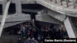 Люди пересекают разрушенный мост, эвакуируясь из города Ирпень по единственному пути отхода, которым пользовались местные жители после нескольких дней сильных обстрелов, в то время как российские войска продвигаются к столице