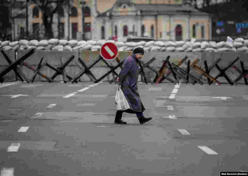 A woman walks in front of a concrete blockade and anti-tank obstacles known as &quot;Czech hedgehogs.&quot; The metal obstacles can stop light armored vehicles and remain effective even if knocked out of position by an explosion.&nbsp;