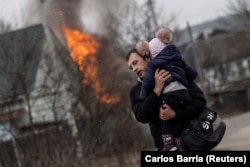 A man and a child flee Russian shelling of the town of Irpin, outside Kyiv, on March 6.