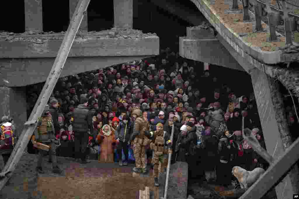 Украинци се крият под разрушен мост, в опит да избягат от Ирпин в покрайнините на Киев, 5 март.
