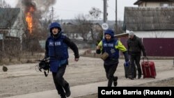 Novinari trče u zaklon nakon granatiranja, Irpin, blizu Kijeva, Ukrajina, 6. marta 2022.