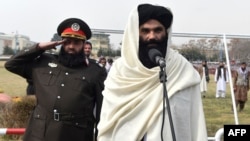 Taliban Interior Minister Sirajuddin Haqqani (right) speaks to new Afghan police recruits during a graduation ceremony at the police academy in Kabul on March 5.