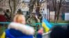 Trupat ruse shihen teksa banorët e Heniçeskut në rajonin Herson protestojnë kundër pushtimit rus. 6 mars 2022.