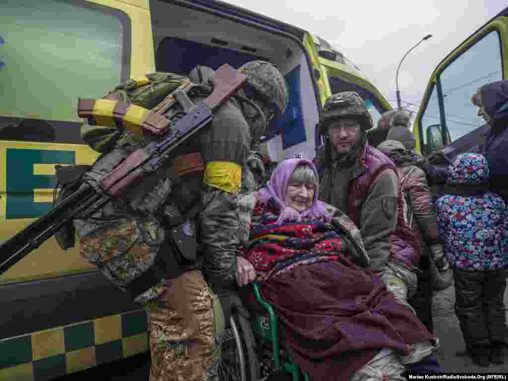Ushtarakët ukrainas ndihmojnë një grua me karrocë.&nbsp;