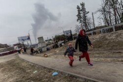 Qytetarët duke vrapuar teksa grantimet në Irpin kanë vazhduar. 6 mars 2022.