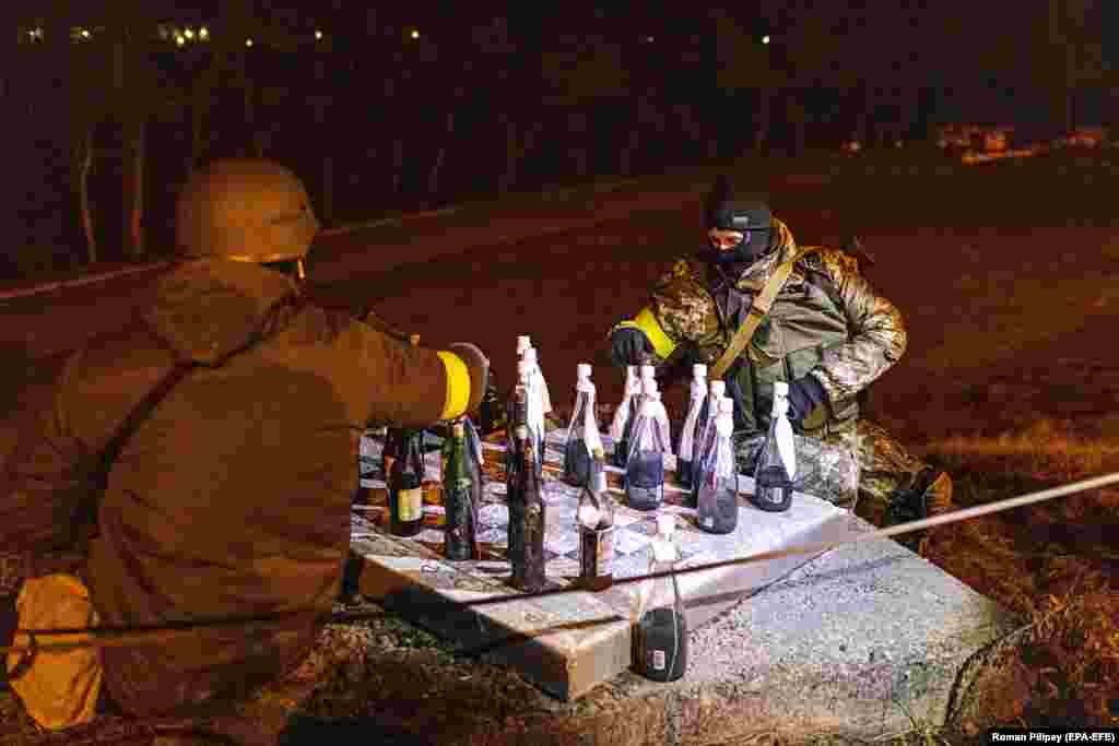 Members of the Territorial Defense Forces play checkers with Molotov cocktails in Kyiv on March 6. A reported 100,000 civilian volunteers have signed up to the Defense Forces since Russia launched a full invasion of Ukraine on February 24.&nbsp;