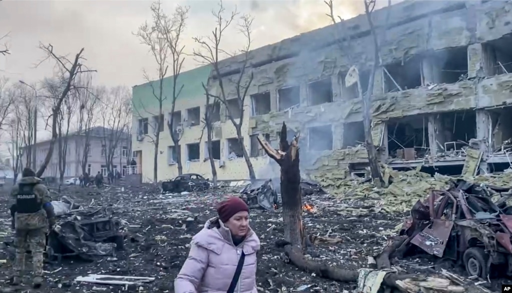 Një grua duke ecur mes rrënojave, pas sulmit rus ndaj spitalit të fëmijëve në Mariupol, më 9 mars.