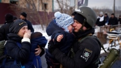 Policajac se oprašta sa sinom i porodicom koji izlaze iz Irpina 8. marta 2022.