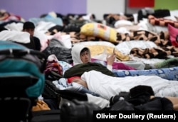 Чоловік лежить на розкладному ліжку в центрі прийому біженців на українсько-польському кордоні в Корчові, Польща, 5 березня 2022 року