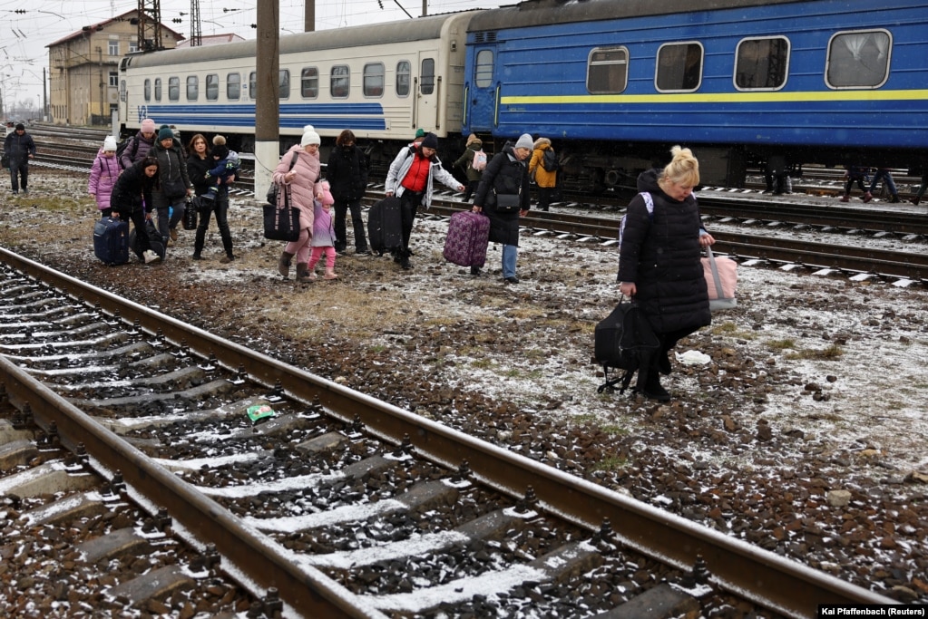 Njerëzit ecin me bagazhet e tyre mes binarëve të trenit, ndërsa refugjatët ikin nga pushtimi rus i Ukrainës, përmes stacionit të trenit në Lviv, Ukrainë, 5 mars 2022
