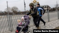 Ukrán katona segít egy kislány kimenekítésében Irpinyből 2022. március 7-én