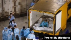 Covidban elhunyt emberek holttestét helyezik el egy fagyasztókonténerben Hongkongban 2022. március 5-én