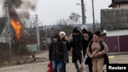 Локални жители бараат засолниште додека бегаат од градот Ирпин, по силното гранатирање на единствениот пат што го користаи локалното население, додека руските трупи напредуваат кон главниот град Киев. Украина, 6 март 2022 година.