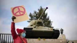 Žena pokazuje znak mira ispred ruskog tenka iz Drugog svjetskog rata na sovjetskom ratnom memorijalu na bulevaru u Berlinu, Njemačka, 27- februara 2022.