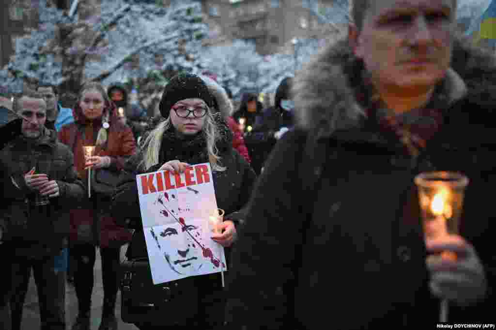 A woman holds an image of Russian President Vladimir Putin with the word &quot;KILLER&quot; during a vigil to support Ukraine in Sofia on March 6.