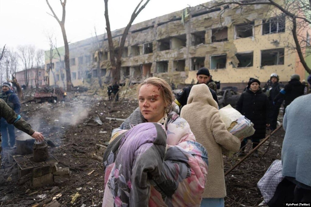 Njerëz duke lëvizur pranë objektit të spitalit të lindjes në Mariupol, pas sulmit ajror të kryer nga Rusia, më 9 mars.