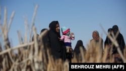 یک زن روستایی و فرزندش در روستای سیخ‌سر در نزدیکی زابل در بهمن ماه ۱۳۹۳