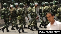 Chinese riot police patrol a street in Urumqi.