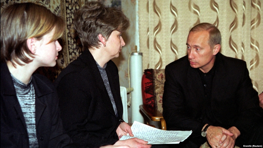 Russian President Vladimir Putin (right) talks with Irina Lyachin, the wife of the commander of the Kursk submarine, and her daughter in their flat in the naval town of Vidyayevo on August 22, 2000. 