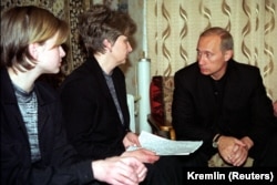 22 august 2000 - Vladimir Putin discută cu Irina Leacina, soția comandantului submarinului Kursk, și cu fiica acestuia, în apartamentul familiei din orașul Videaevo.