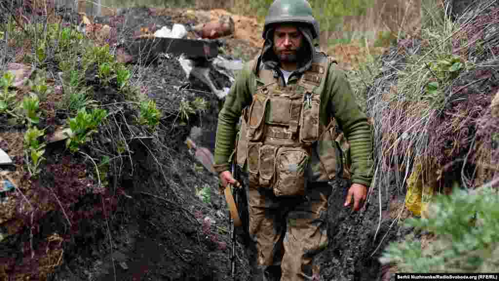 Український військовий йде в окопі на позиціях на лінії фронту. Донецька область, 22 квітня 2022 року