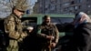 A woman offers consecrated Easter cake and eggs to Territorial Defense members outside a church in Bucha, outside Kyiv, on April 24.