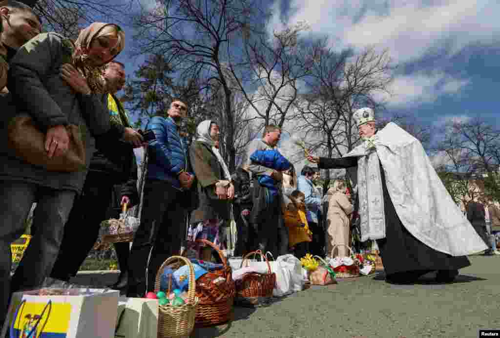 An Orthodox priest sprays holy water on believers during the Orthodox Easter service outside St. Volodymyr&#39;s Cathedral in Kyiv.