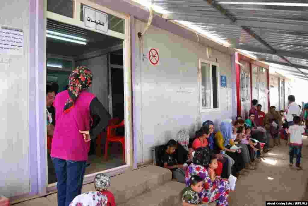 Syrian refugees wait at the health center at the refugee camp in Domeez.