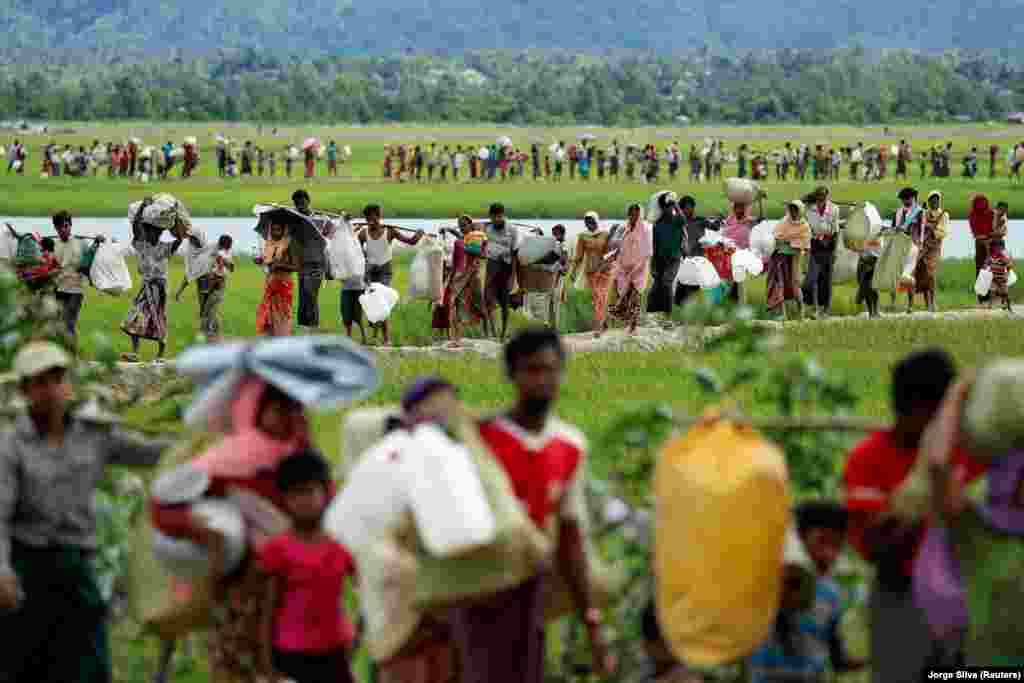 Rohingya refugees, who crossed the border from Burma two days before, walk after they received permission from the Bangladeshi Army to continue on to refugee camps in Palang Khali, near Cox's Bazar, Bangladesh. (Reuters/Jorge Silva)