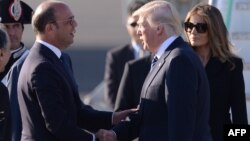 Президента США Дональда Трампа и его супругу Меланью Трамп в аэропорту Фьюмичино приветствует министр иностранных дел Италии Анджелино Альфано (слева). Рим, 23 мая 2017 года.