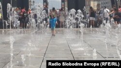 Илустрација: Дете се разладува во фонтаната на плоштадот Македонија во Скопје