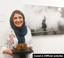 Yalda Moayeri poses with her photograph.