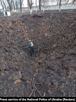 Сапёр правярае варонку ад выбуху каля дзіцячага шпіталю ў Марыюпалі пасьля бамбаваньня 9 сакавіка 2022