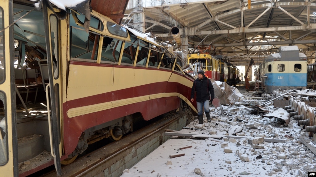 Bir sakin, 12 Mart'ta Kharkiv'de yıkılan bir tramvay deposunu inceliyor.