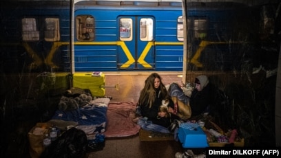 Një vajzë me macen e saj në një stacion metroje në Kiev më 8 mars 2022, ku shumë njerëz u detyruan të strehoheshin. Skenat që të kujtojnë Luftën e Dytë Botërore tronditën botën në fillim të marsit, ndërsa civilët ukrainas u zhvendosën nën tokë për të qenë më të sigurt, derisa Rusia sulmoi me raketa në disa qytete të mëdha.