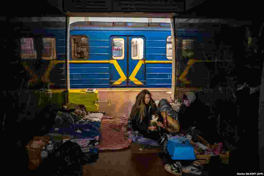 Një grua ukrainase duke përqafuar macen e saj brenda një vagoni treni, në një stacion nëntokësor hekurudhor, i cili po përdoret si strehim kundër bombave, në Kiev, Ukrainë, më 8 mars.