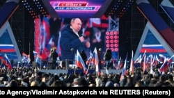 People watch a broadcast of Russian President Vladimir Putin's speech during a concert marking the eighth anniversary of Russia's annexation of Crimea outside Luzhniki Stadium in Moscow on March 18.