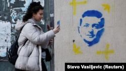 Podgorica: Djevojka prolazi pored grafita sa likom ukrajinskog predsjednika Volodimira Zelenskog, mart 2022.