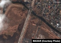 Műholdfelvétel a Maxar Technologies jóvoltából. A képen a megrongált Irpiny-folyó hídjánál várakozó hosszú gépkocsioszlop és emberek 2022. március 10-én