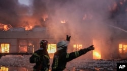 Pompierii ucraineni sting un incendiu la un depozit după un bombardament la Kiev, Ucraina, joi, 17 martie 2022.