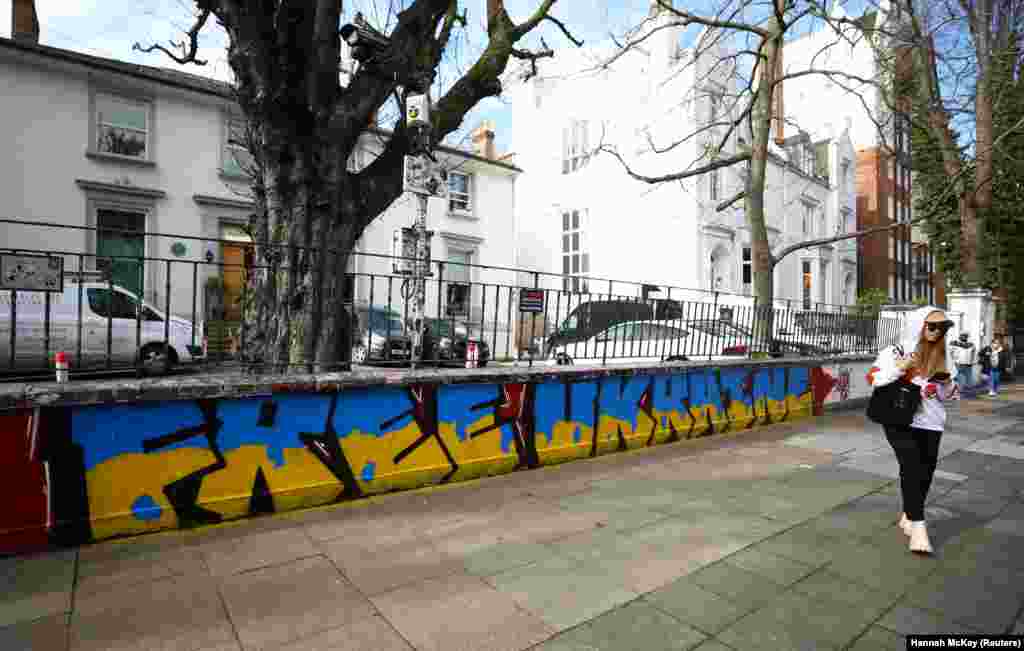 Žena hoda u blizini grafita podrške Ukrajini, ispred Abbey Road Studios, London, Velika Britanija, 14. mart 2022.