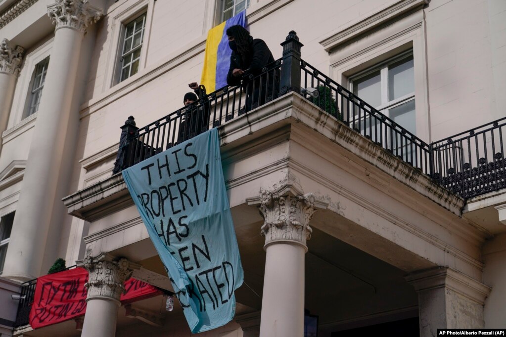 Disa persona në Londër, Britani, duke shfaqur banderola dhe një flamur ukrainas, teksa okuponin më 14 mars një ndërtesë, e cila besohet se është pronë e oligarkut rus, Oleg Deripaska.