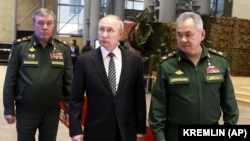 Soldan sağa: Rusiya Silahlı Qüvvələri Baş Qərargahının rəisi general Valeri Gerasimov, Vladimir Putin və müdafiə naziri Sergey Şoyqu, 