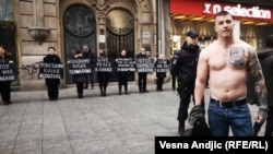 A man with a large tattoo on his chest of Bosnian Serb wartime commander Ratko Mladic, a convicted war criminal, stands near a protest against Russia's invasion of Ukraine on March 16.