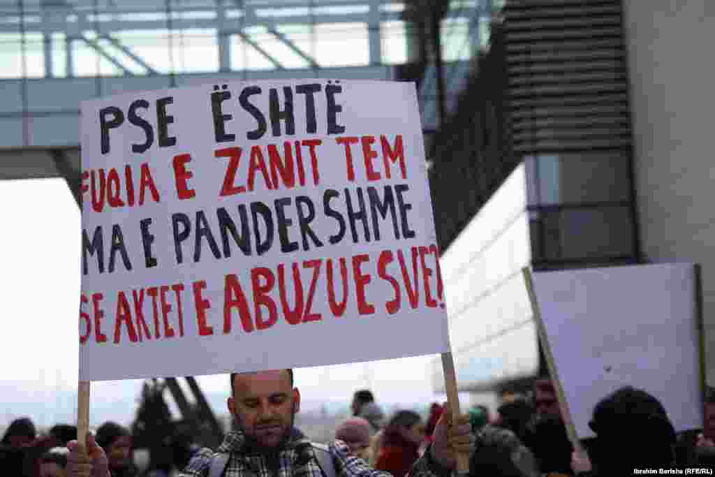 Një pjesëmarrës në protestën e organizuar në Prishtinë më 8 mars, duke mbajtur një pano ku shkruan &ldquo;Pse është fuqia e zanit tem ma e pandershme se aktet e abuzuesve?&rdquo;.